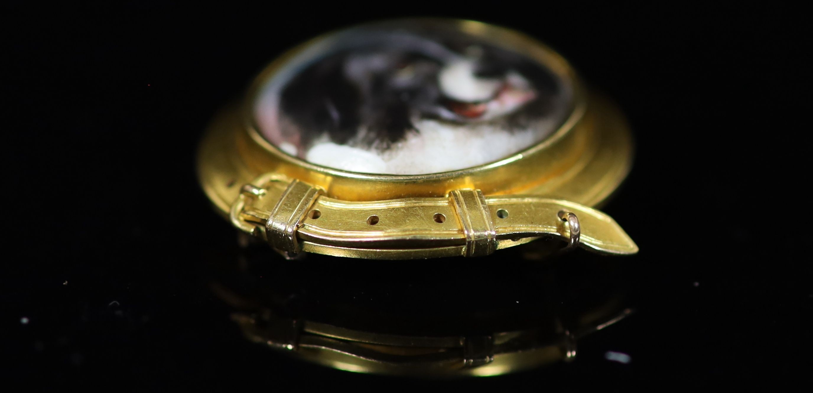 A Victorian gold and enamel circular brooch, decorated with the head of a dog, inscribed verso 'W. Essex, 1863'